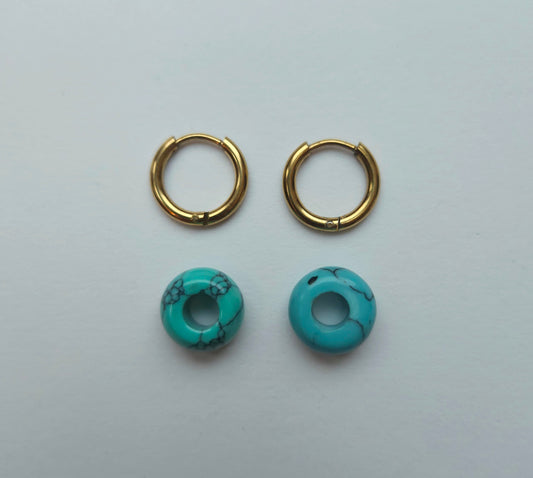 Gold hoop earrings with turquoise stone beads on a light gray background