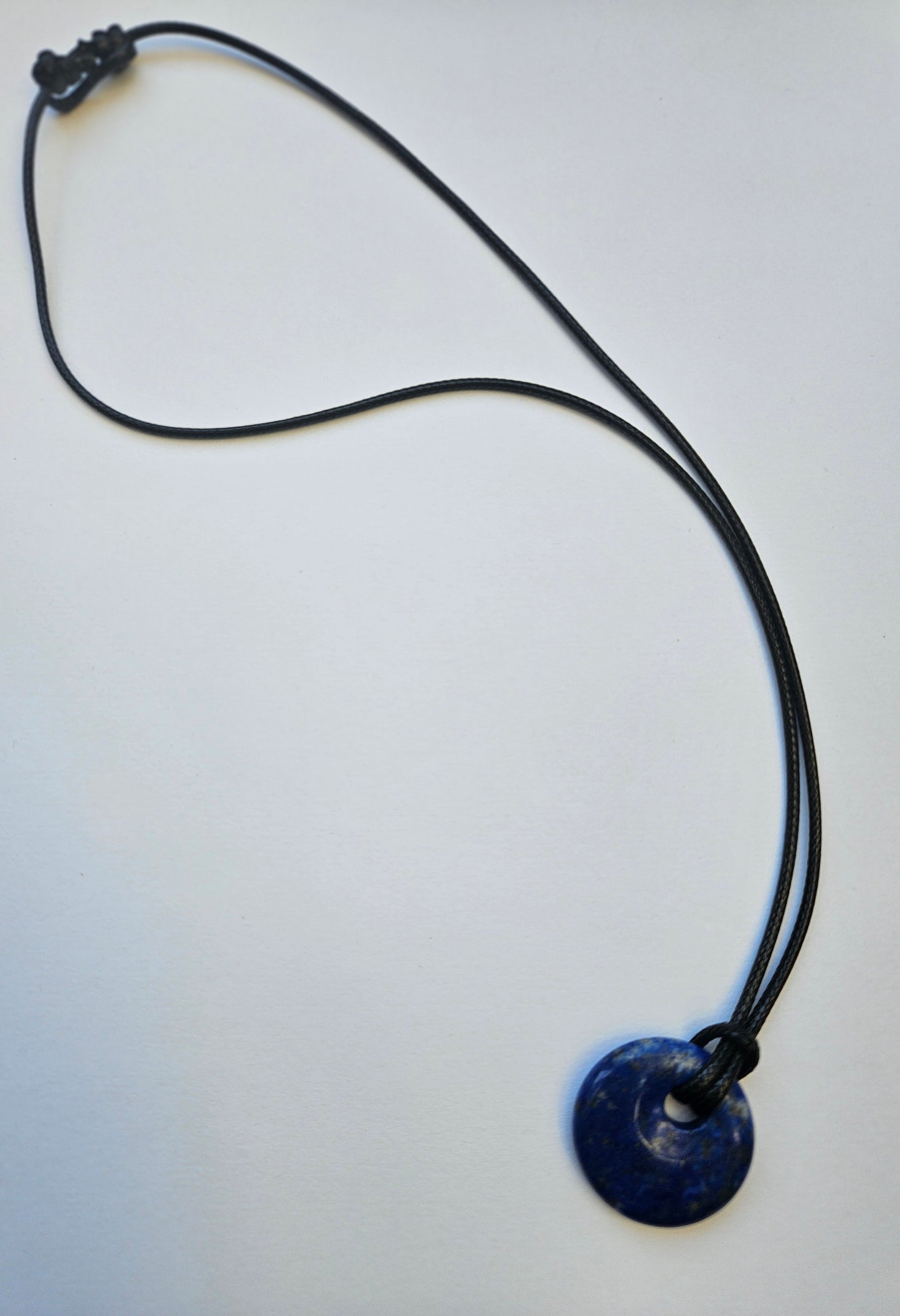 Necklace with a cobalt blue lapis pendant on a white background