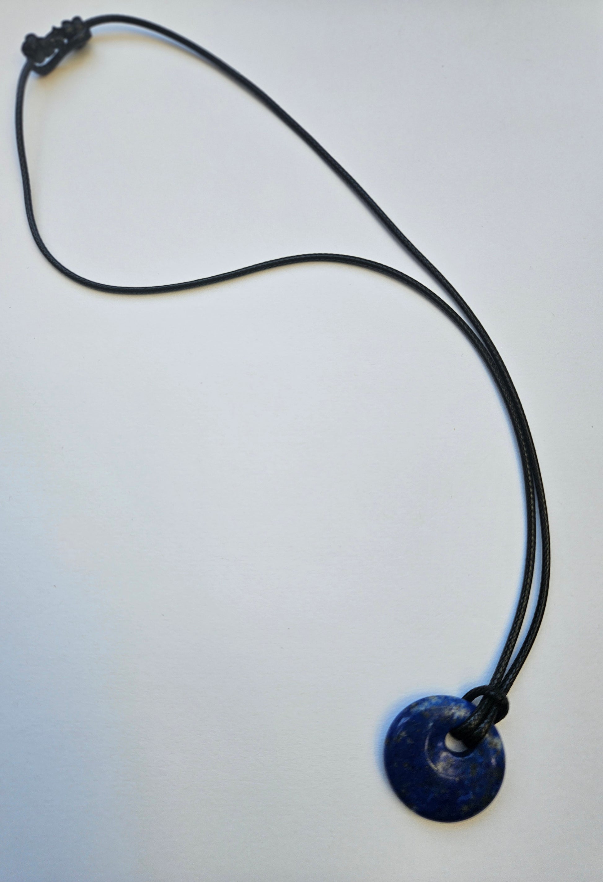 Necklace with a cobalt blue lapis pendant on a white background
