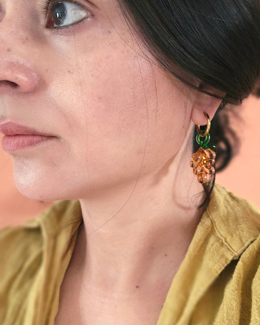 Close up of a woman wearing a grape earring.