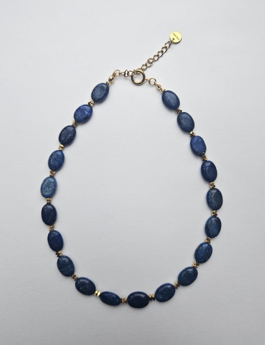 Necklace with blue beads on a light gray background
