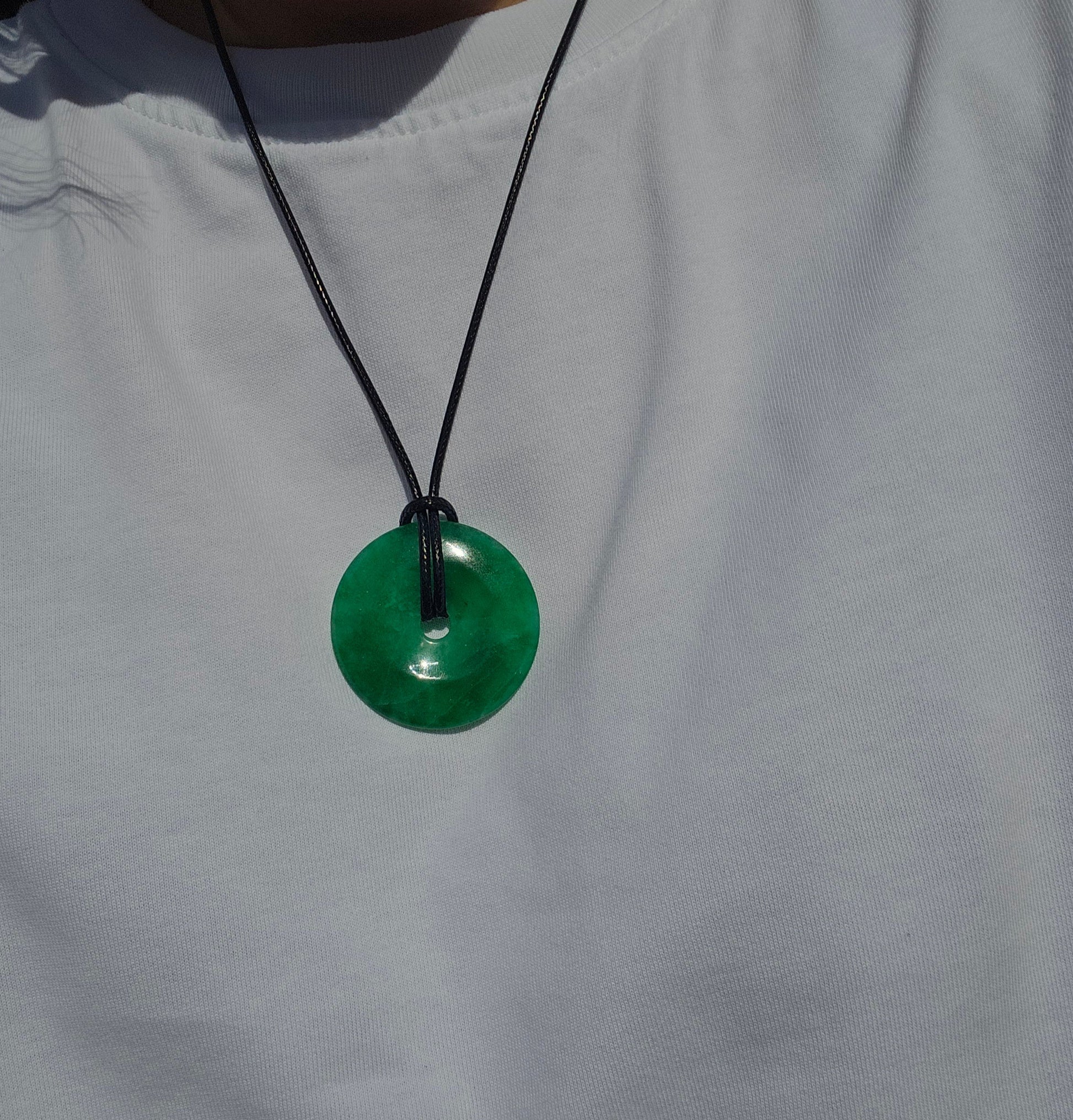Green pendant necklace on a white shirt