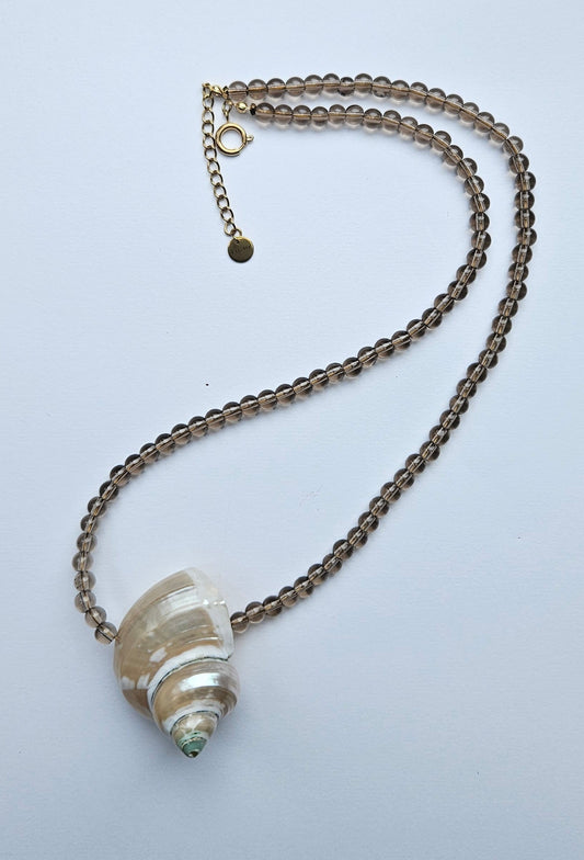 Necklace with a shell pendant on a light gray background
