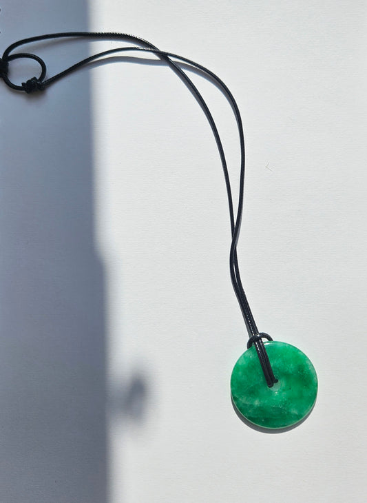 Green jade round pendant on a leather cord