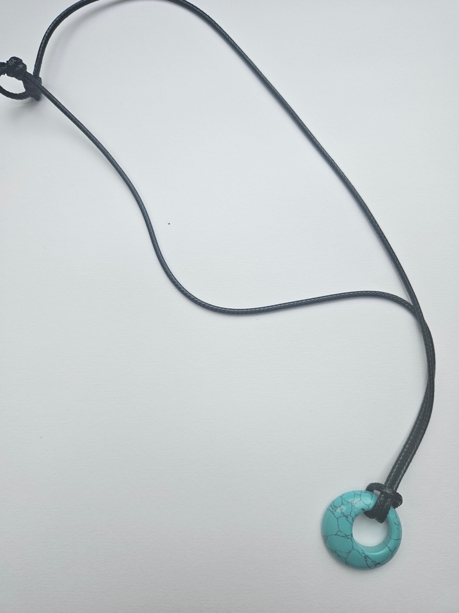 Necklace with a turquoise pendant on a white background