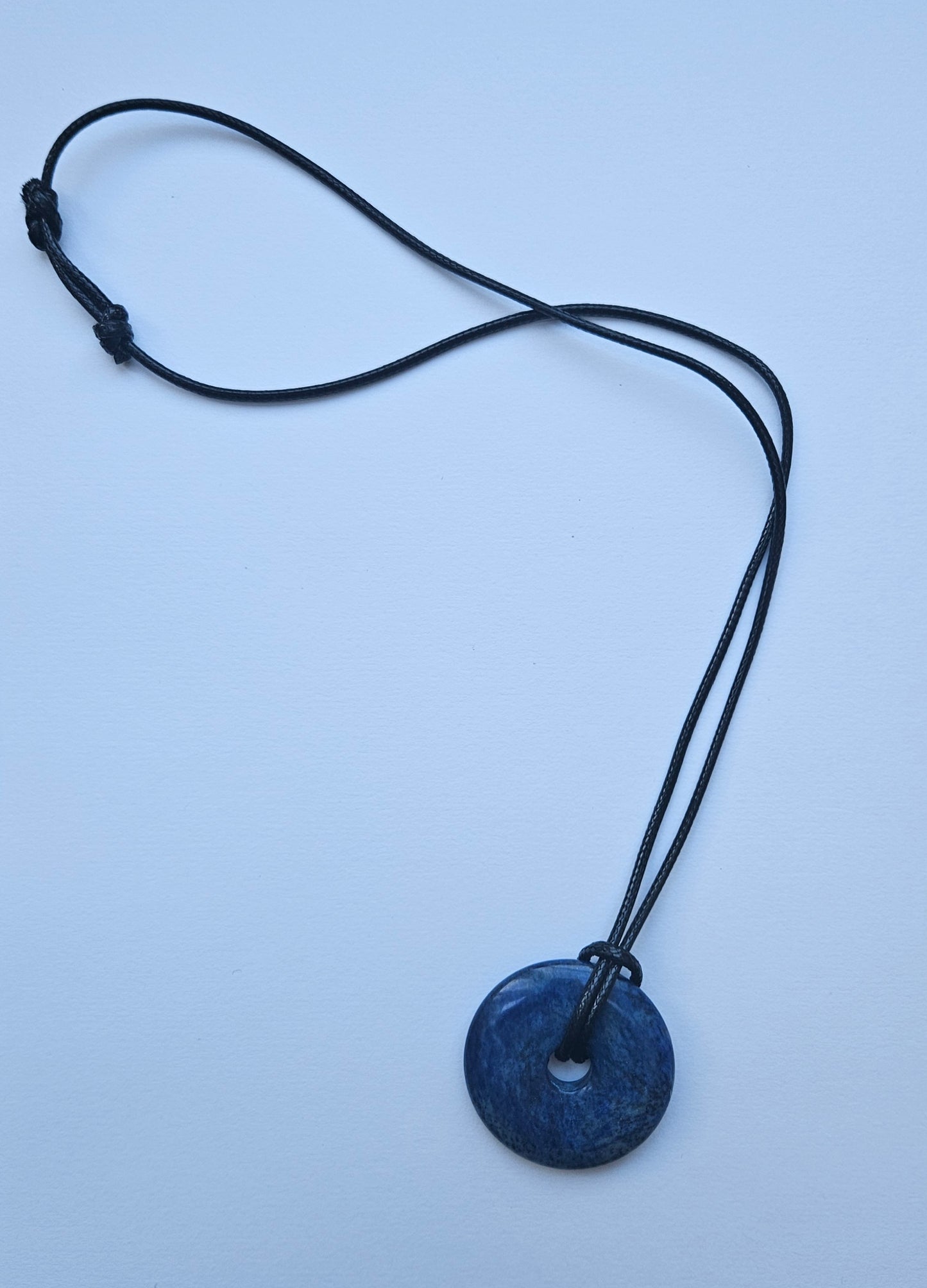 Blue pendant necklace on a light blue background