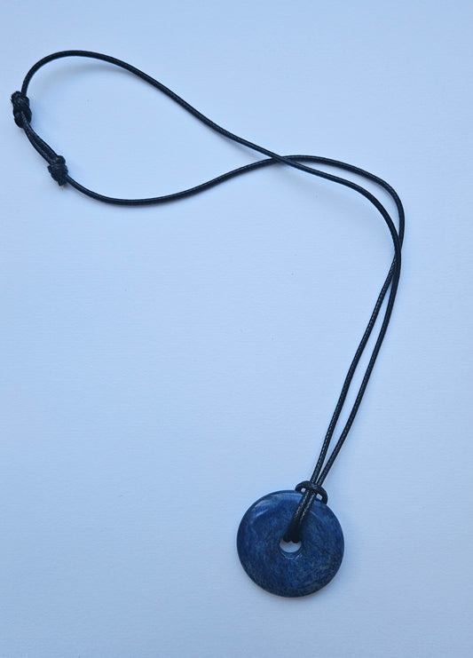 Blue pendant necklace on a light blue background