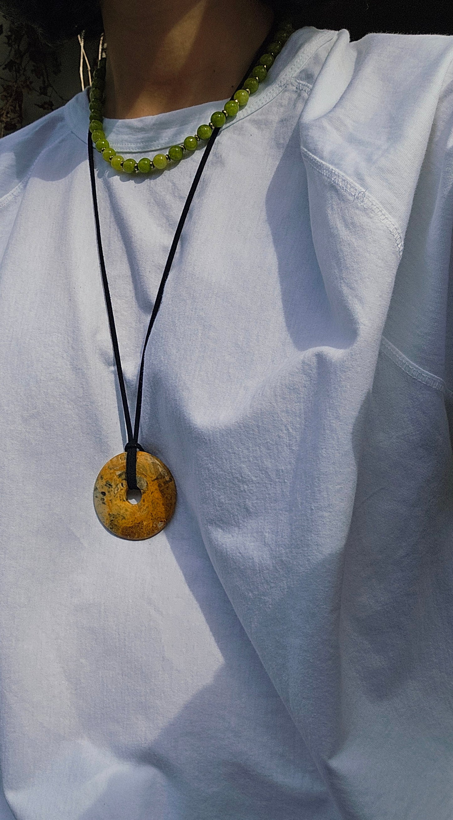 Necklace with a round pendant on a white shirt