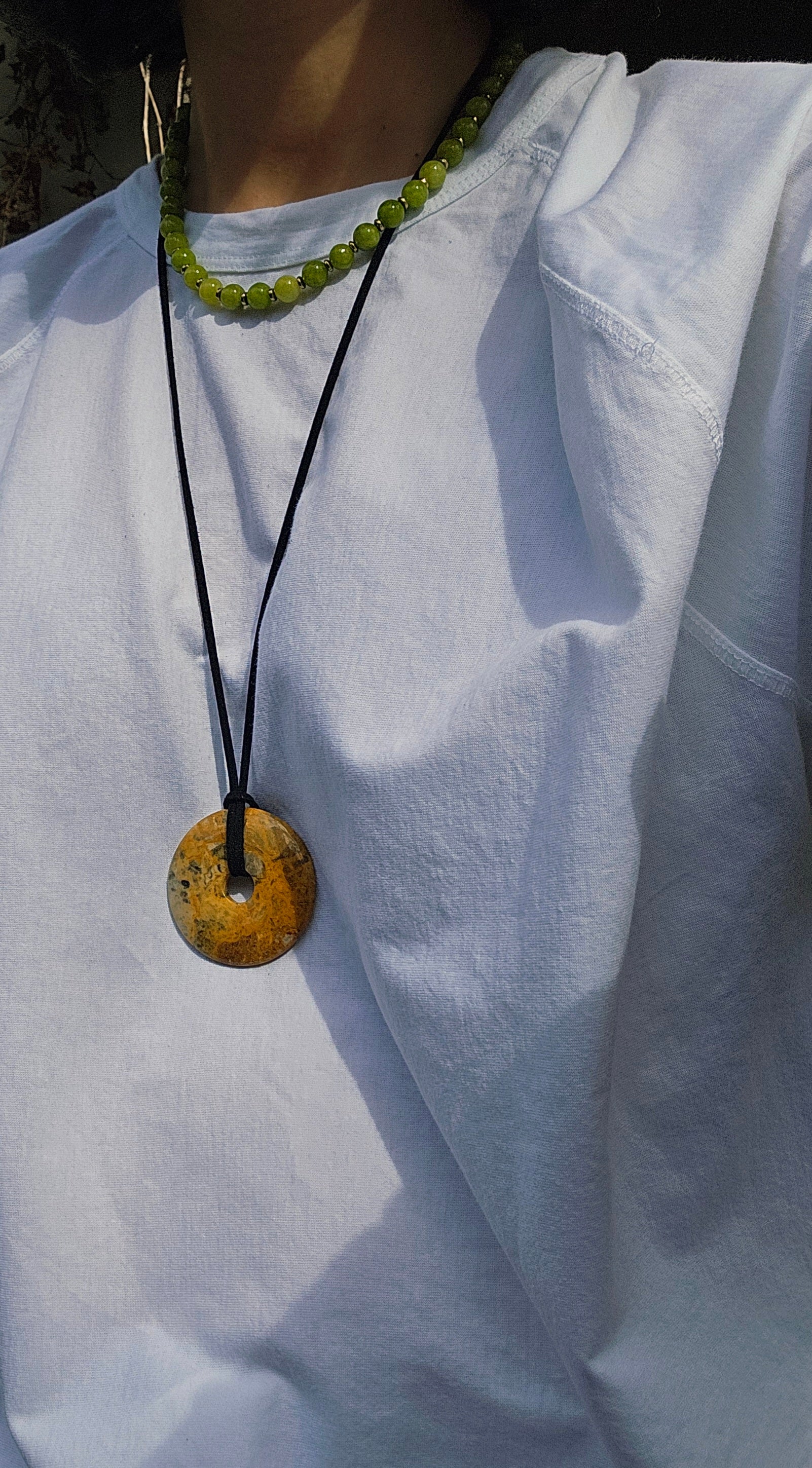 Necklace with a round pendant on a white shirt