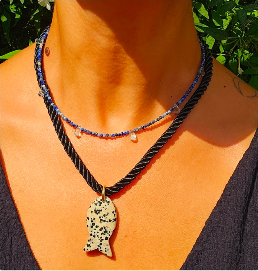 Dalmatian jasper fish pendant on a black silk rope.